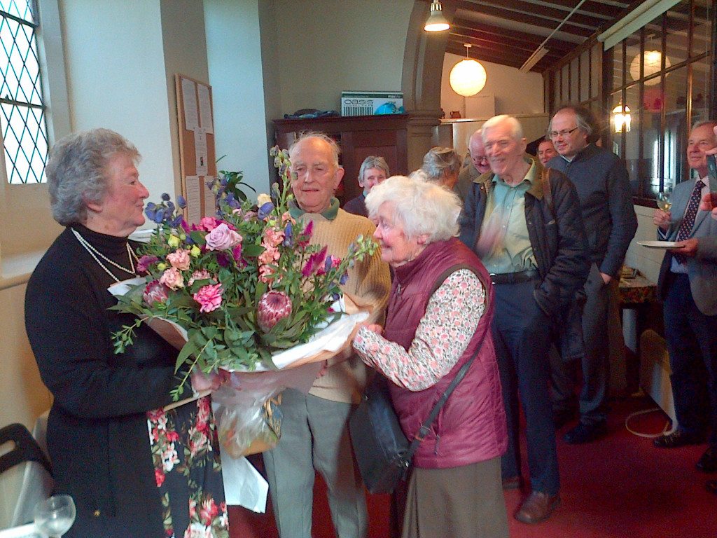 Anne Jarman is presented with flowers by Anne Clutterbuck during the party to thank her for all the wonderful years of organising parties for the congregation of St Vincent's. Anne's husband Alan looks on. 5th September 2015. Photo by Allan Maclean.