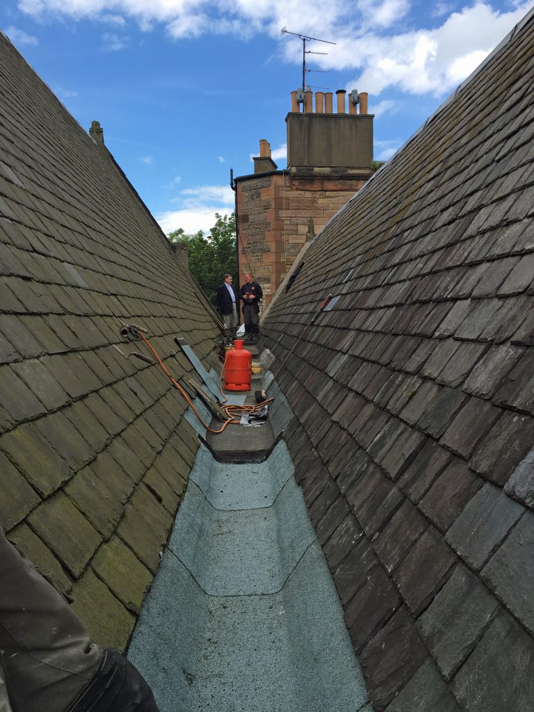 The Rector (left) talking to roofer Raymond Ewing during repair work in June 2016