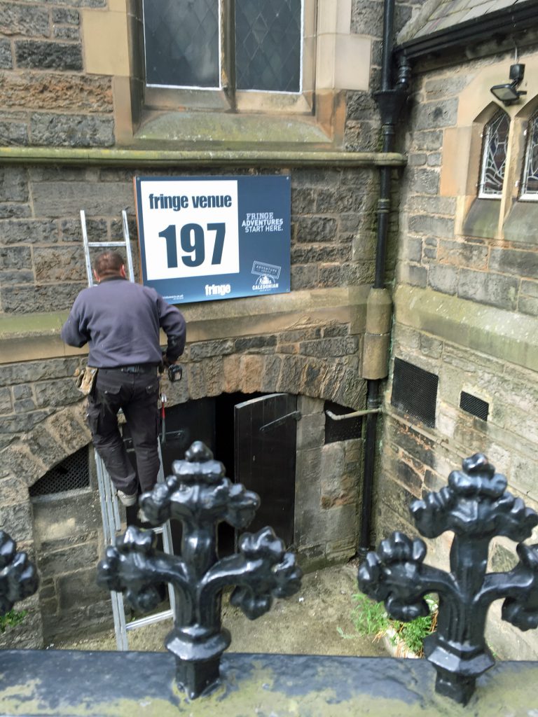 Stuart put this year's Fringe Venue sign in place