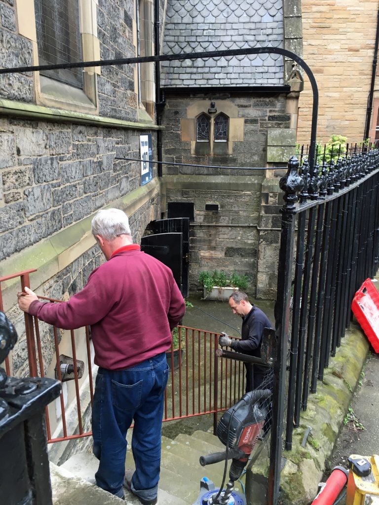 A new railing is fitted to the steps to the undercroft at St Vincent's by father and son Graeme Brodie, blacksmiths. There had been no railing previously.